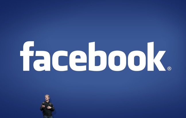 Logo do Facebook ao fundo com Mark Zuckerberg à frente