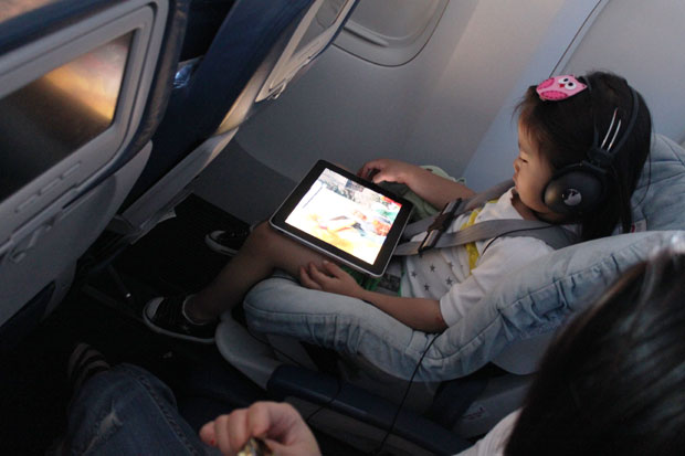 Garotinha usando iPad em avião