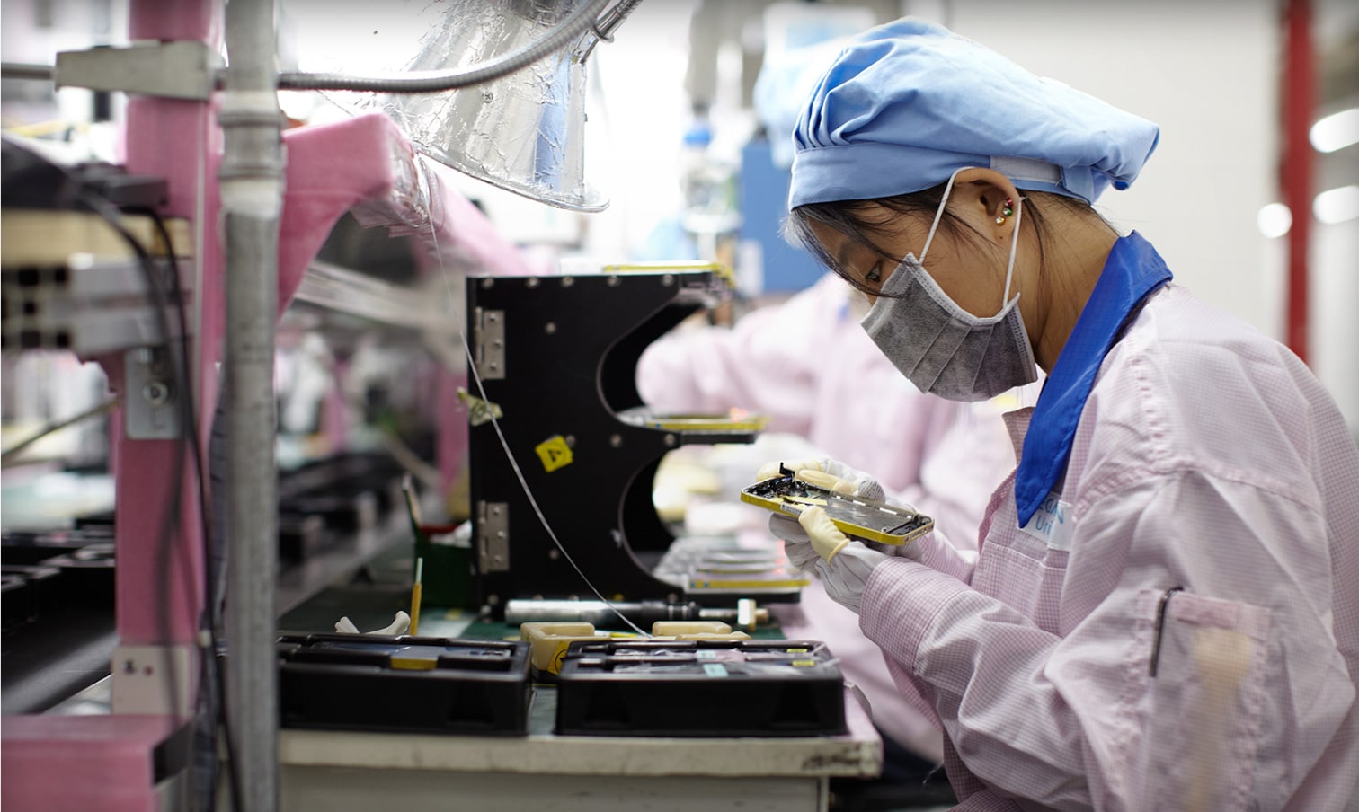 Trabalhadora em fábrica da Foxconn montando iPhone
