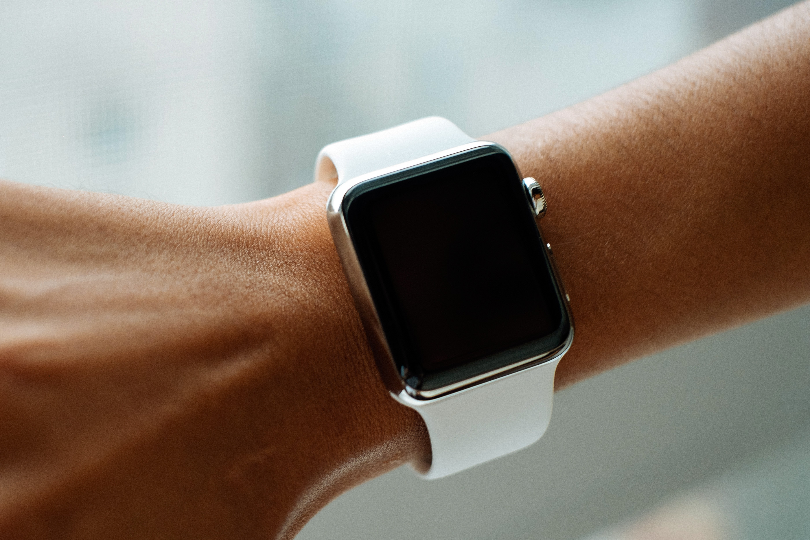 Apple Watch com pulseira Sport branca no braço