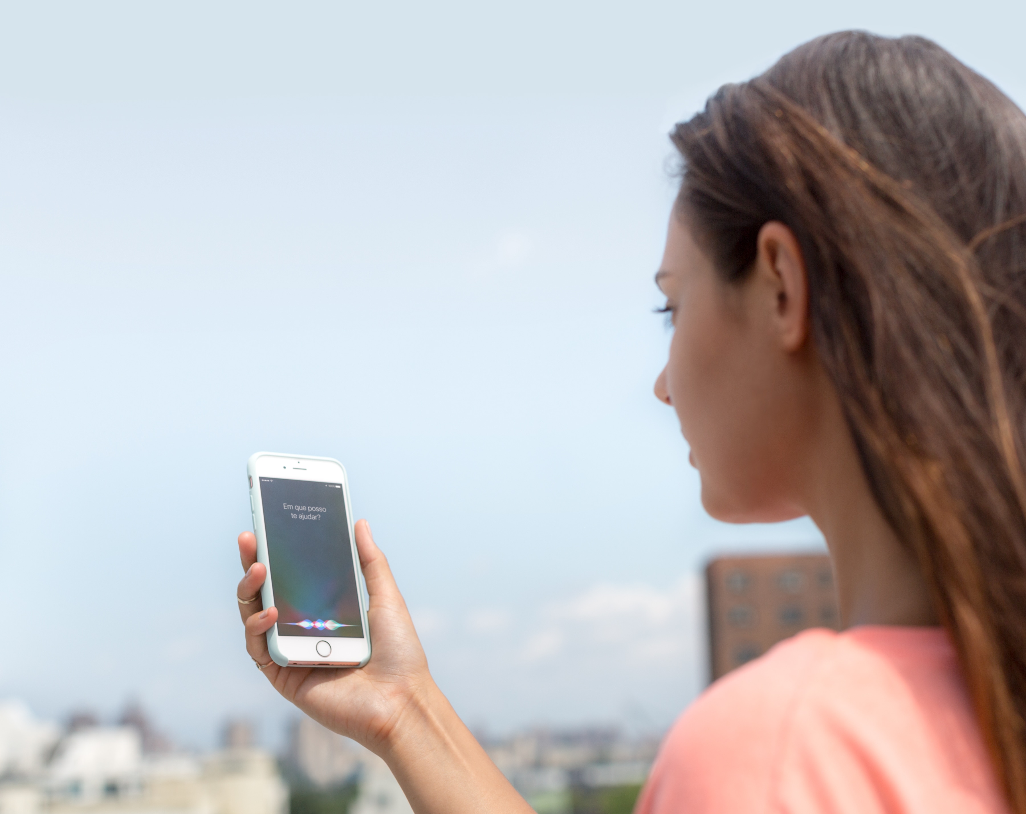 Mulher usando a Siri num iPhone ao ar livre