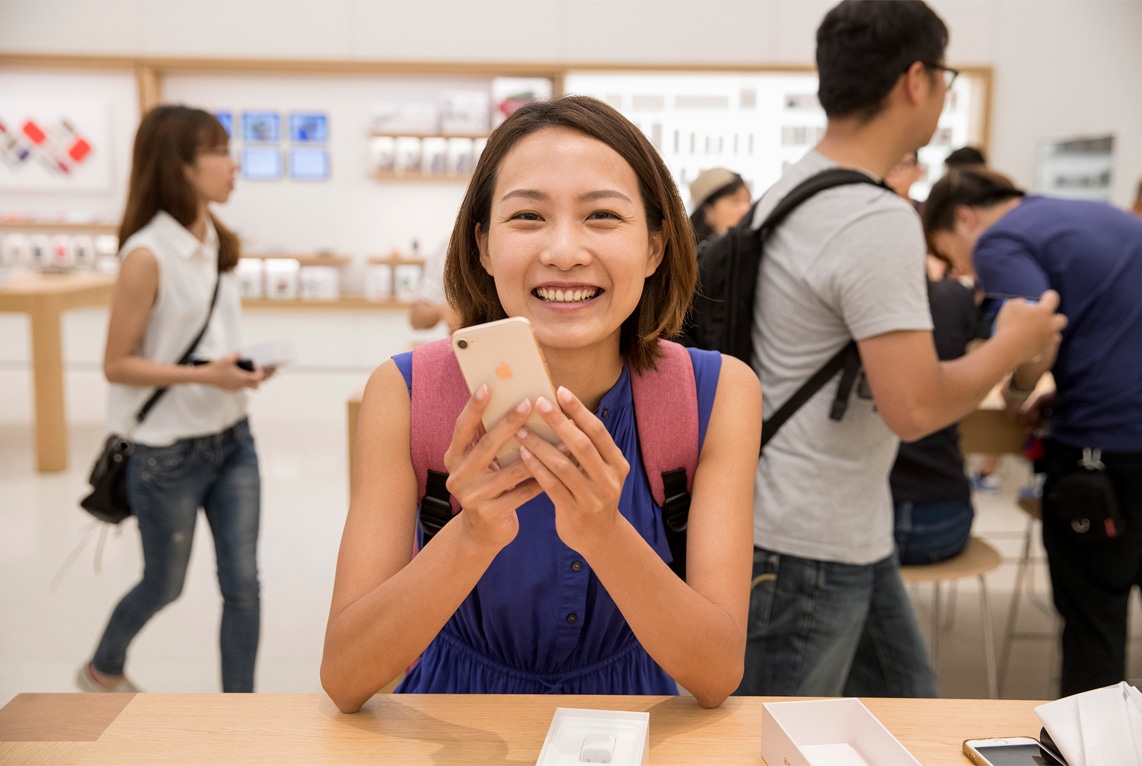 Mulher usando iPhone 8 em Apple Store