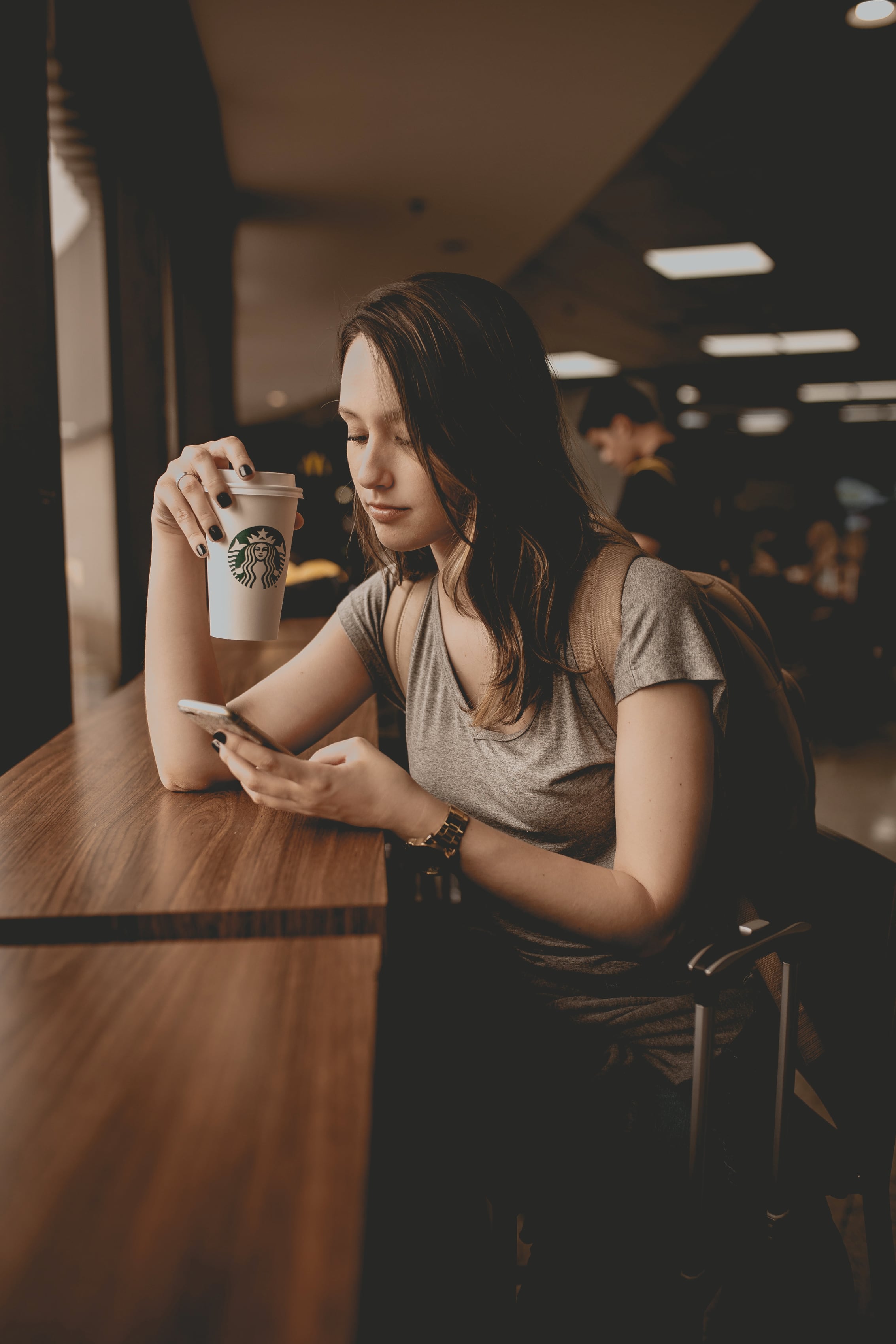 Mulher usando iPhone em uma Starbucks