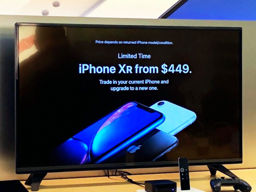 Apple TV em mostruário divulgando iPhone XR na Apple Haywood Mall