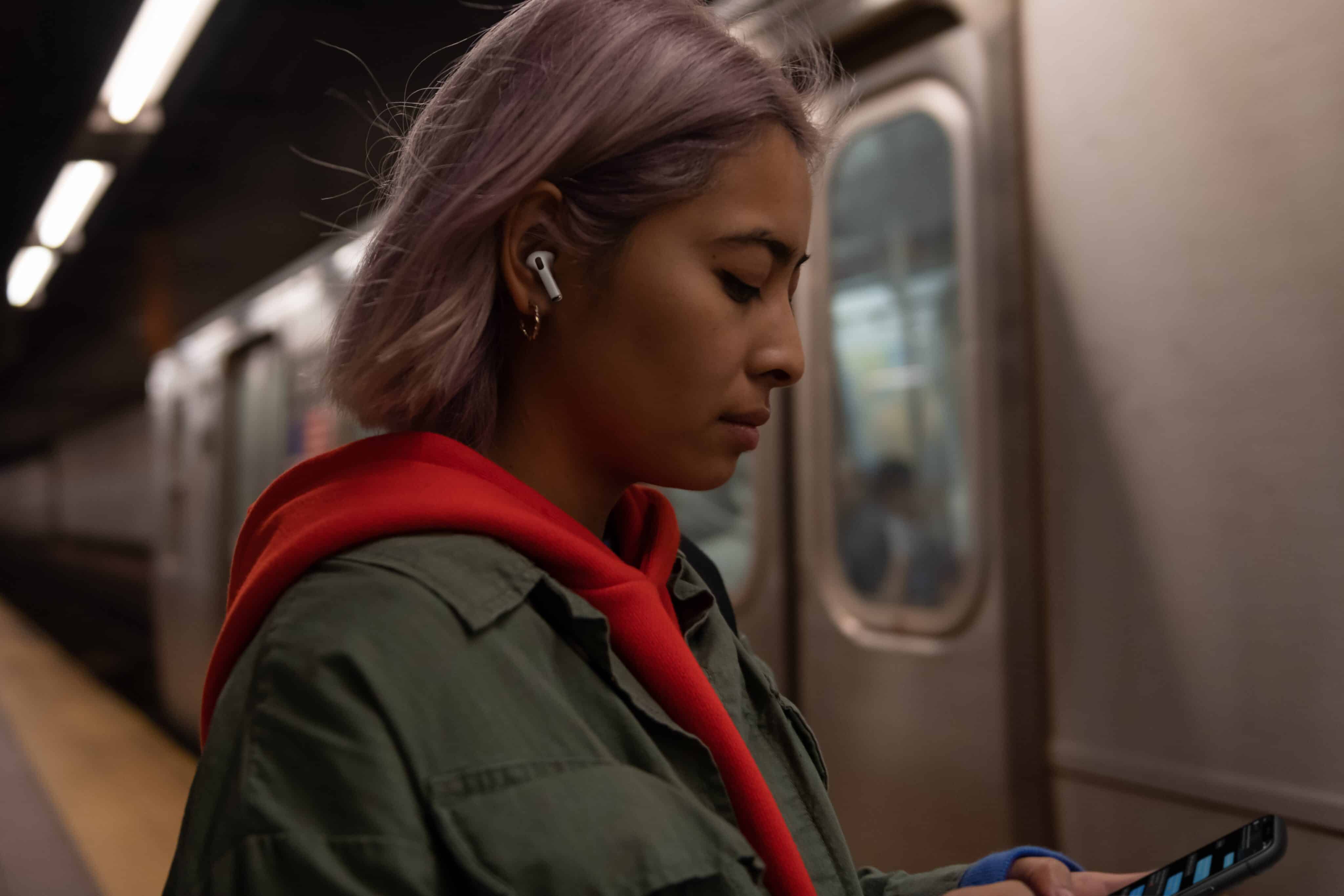 Mulher usando os AirPods Pro no metrô