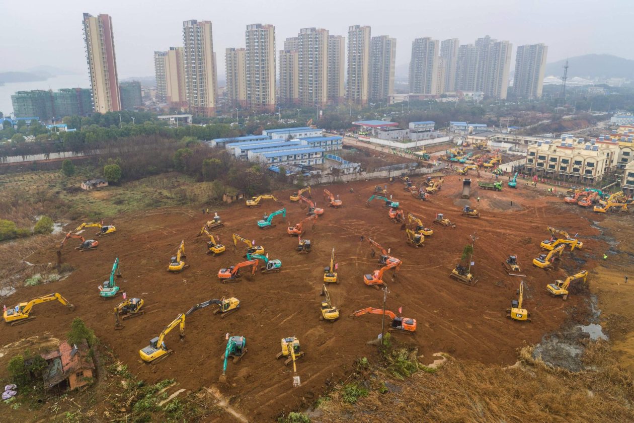 Tratores escavando para a construção de hospital na cidade de Wuhan