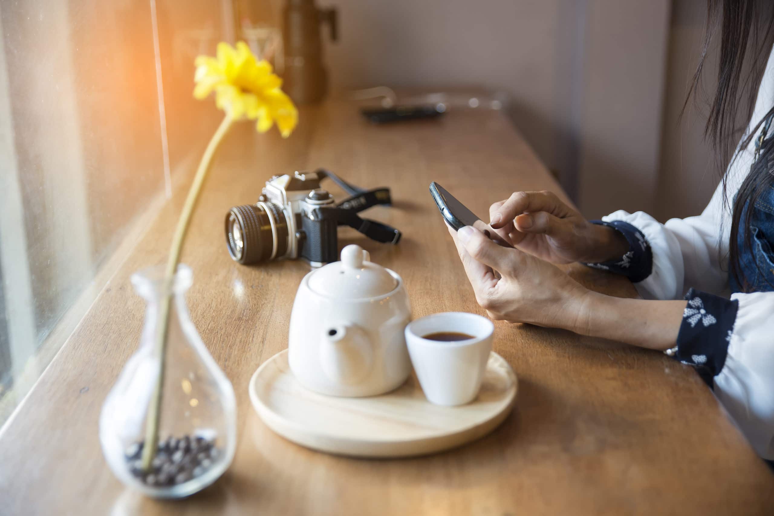 Leitura em iPhone com café e flor