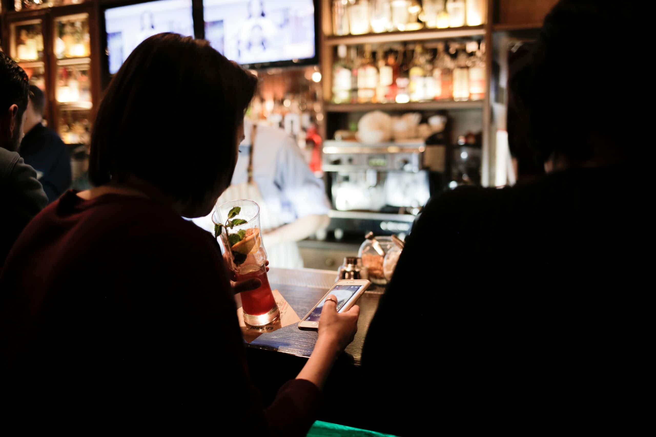 Pessoas num bar usando smartphone