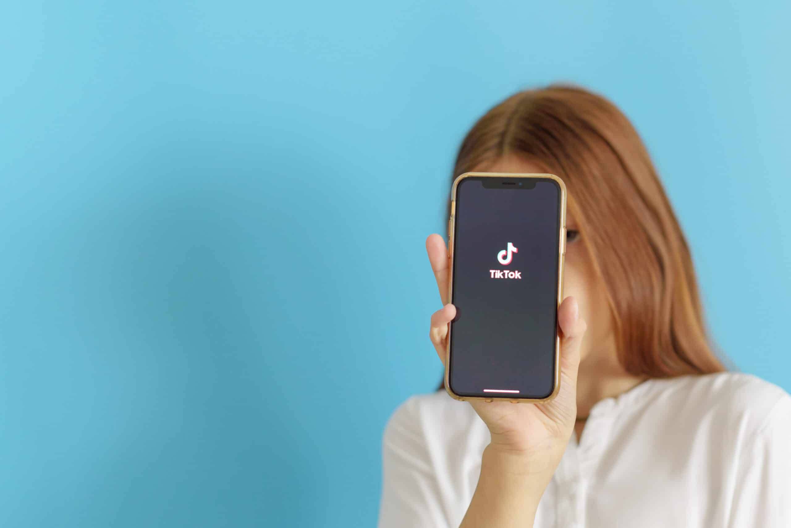 Menina mostrando um iPhone com TikTok