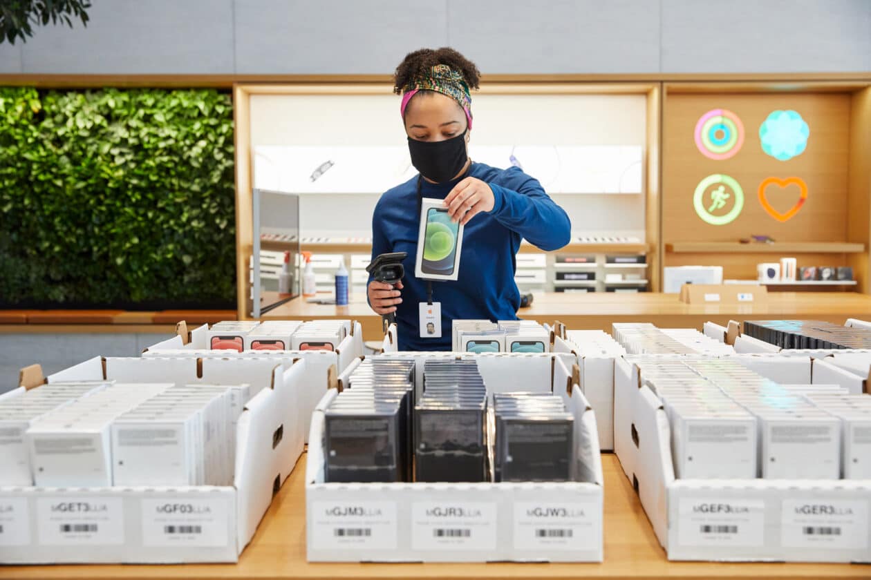Empregada de Apple Store identificando caixas de iPhones 12 e 12 Pro