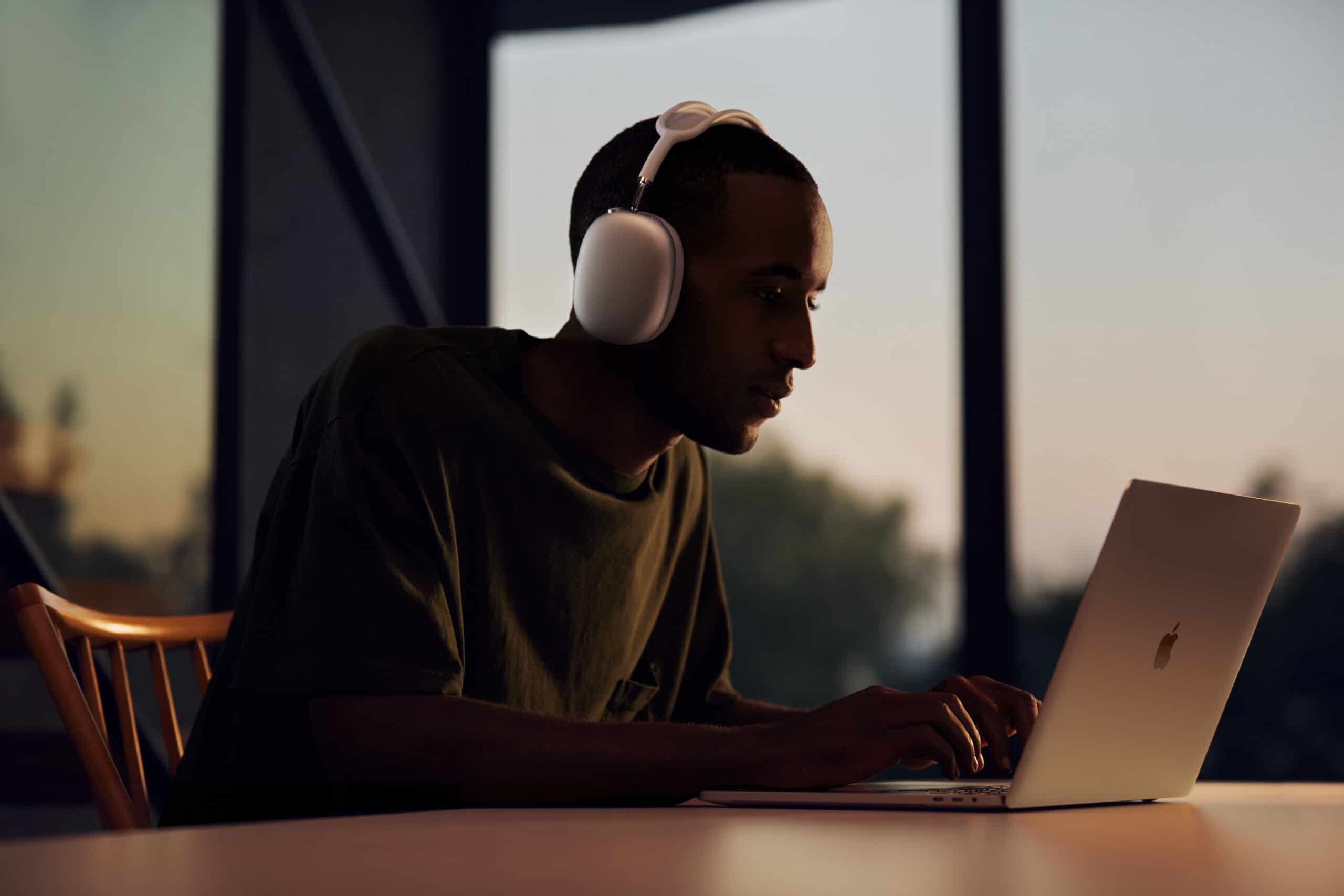 Homem ouvindo AirPods Max com MacBook Pro