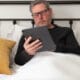 Homem trabalhando em iPad Pro na cama