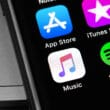 iPhone com ícones da App Store, da iTunes Store, do Música e do Spotify