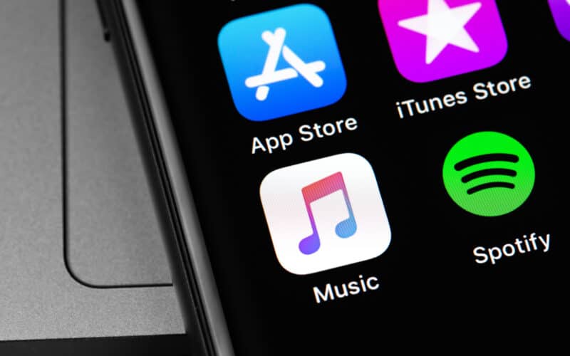 iPhone com ícones da App Store, da iTunes Store, do Música e do Spotify