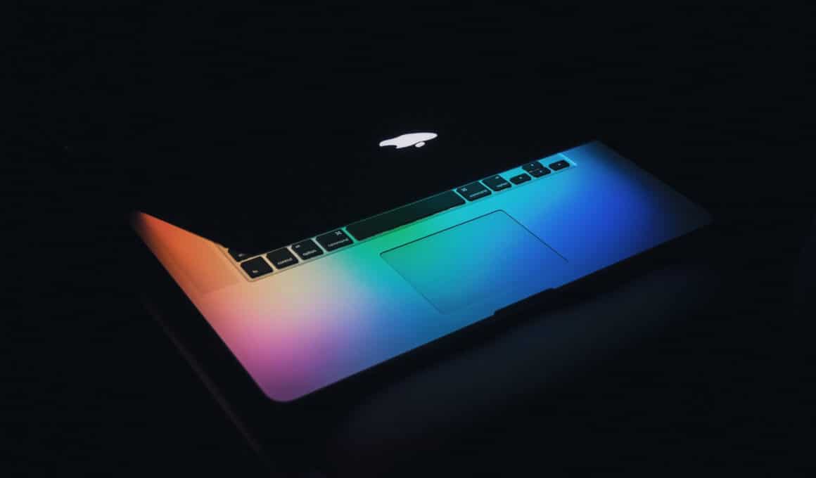 MacBook Pro com wallpaper colorido e a tampa quase fechada