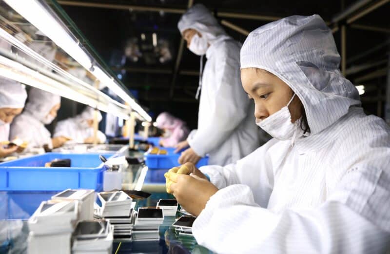 Trabalhadores chineses usando máscaras na fábrica