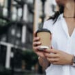 Mulher com Apple Watch segurando um café