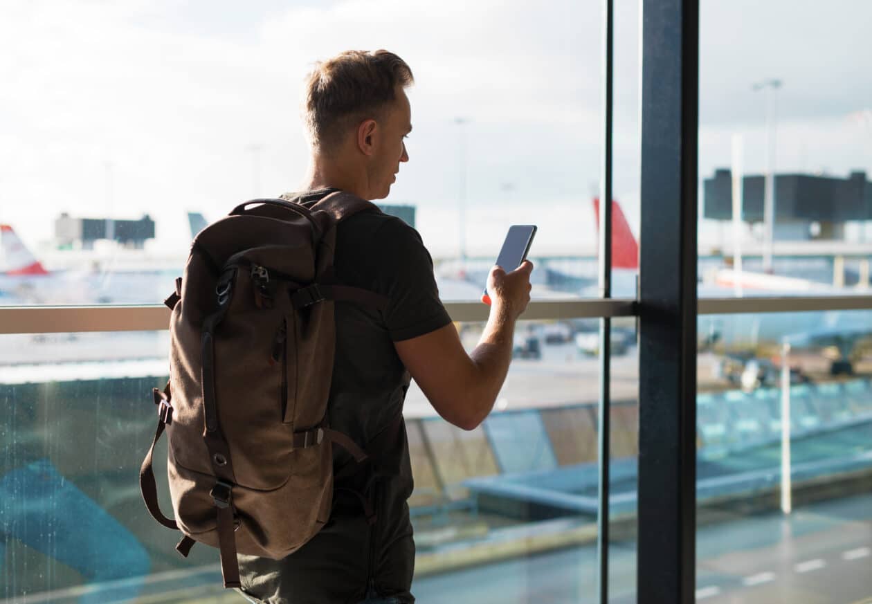 Homem viajando com um iPhone na mão