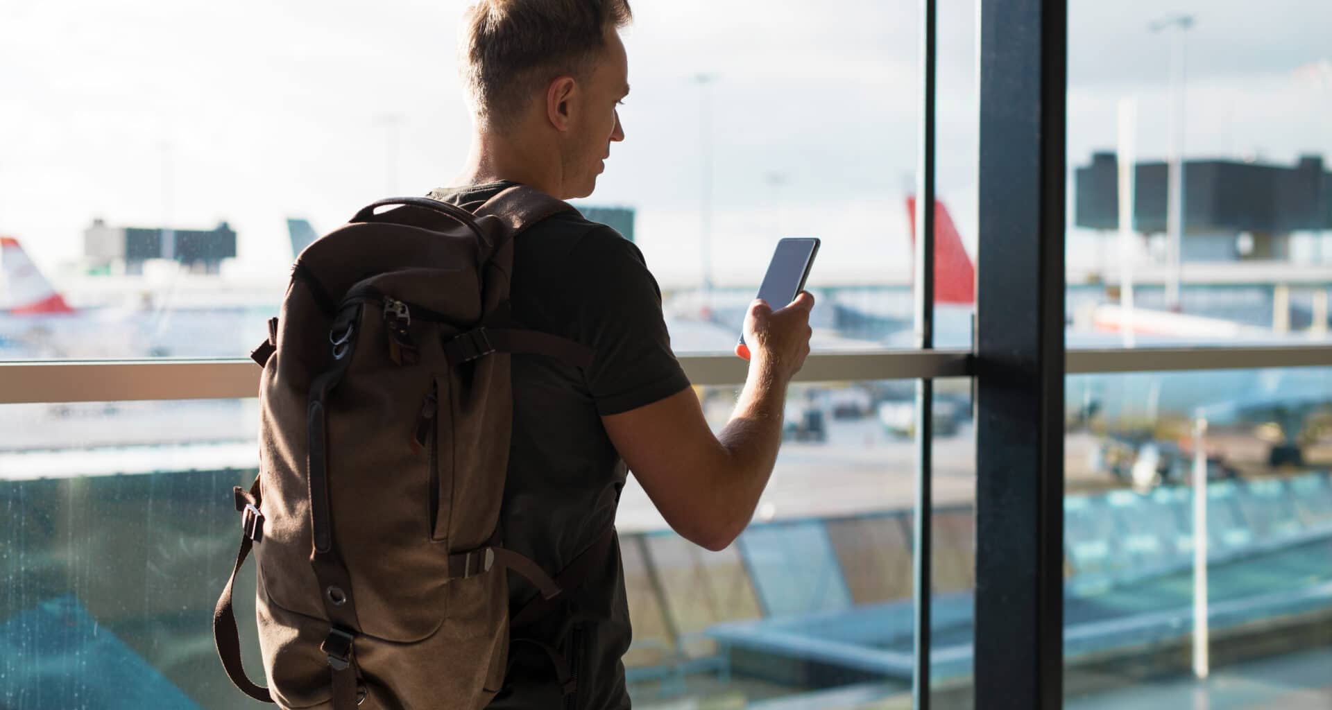 Homem viajando com um iPhone na mão