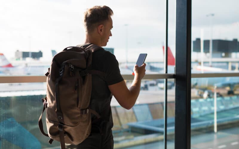 Homem viajando com um iPhone na mão