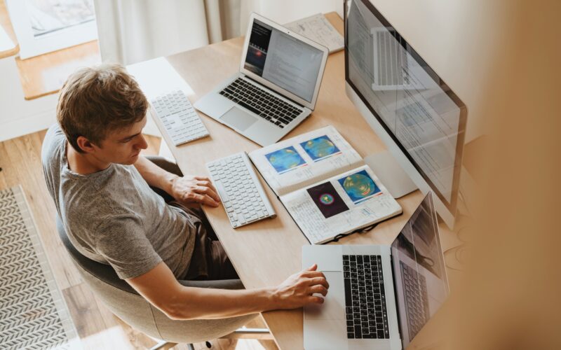 Homem trabalhando com vários Macs