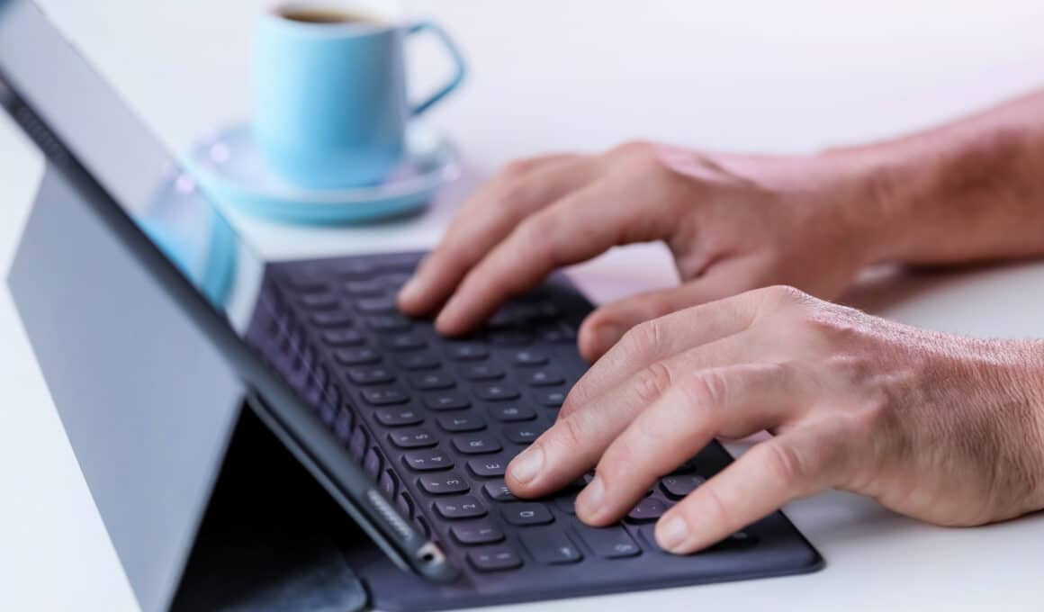 Homem digitando em Smart Keyboard conectado a iPad