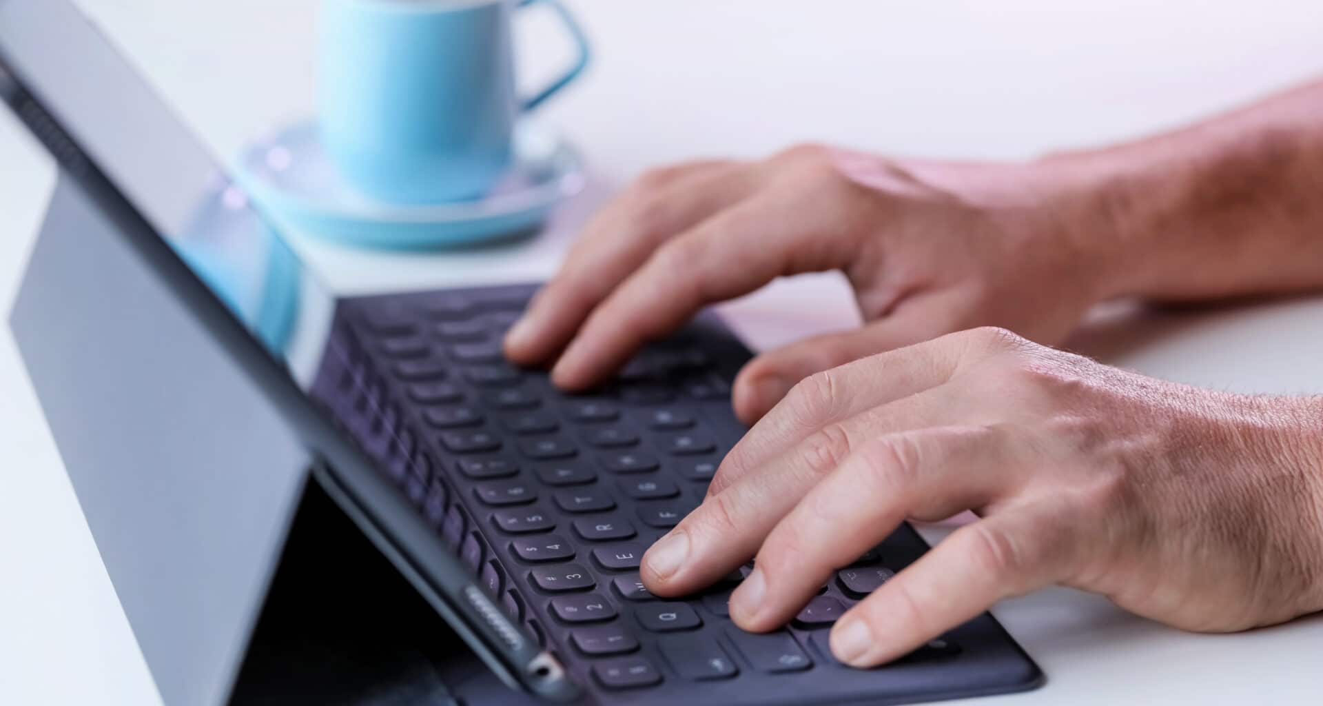 Homem digitando em Smart Keyboard conectado a iPad