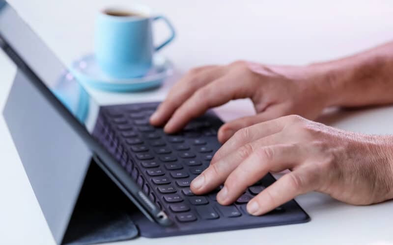 Homem digitando em Smart Keyboard conectado a iPad