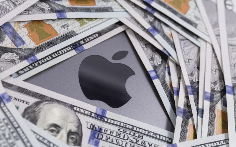 Dinheiro em cima de um MacBook Pro com o logo da Apple
