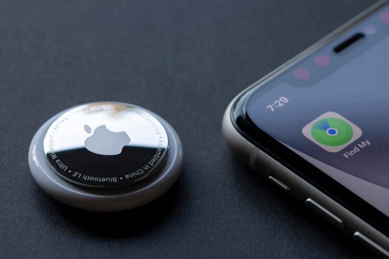 AirTag ao lado de um iPhone com o app Buscar
