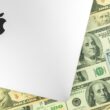 Logo da Apple (MacBook Pro) e dinheiro ao fundo