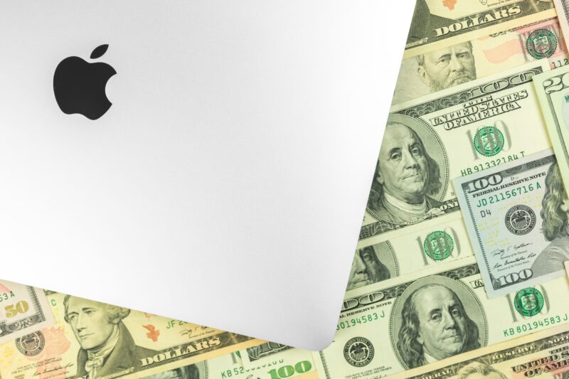 Logo da Apple (MacBook Pro) e dinheiro ao fundo