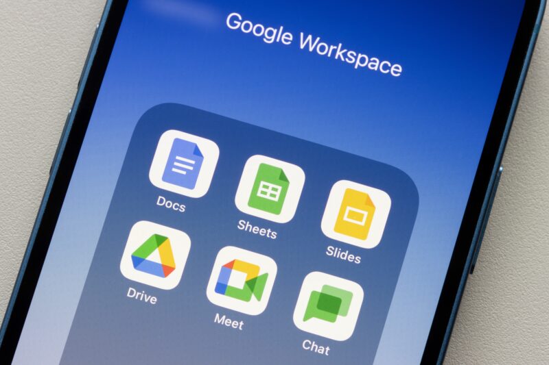 iPhone com pasta do Google Workspace (Docs, Sheets, Slides, Drive, Meet e Chat)