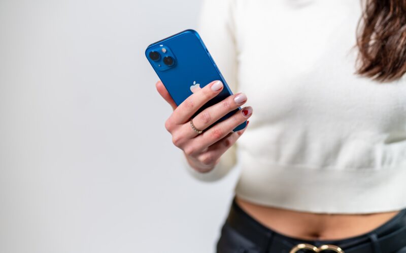 Mulher segurando iPhone 13 (mini?) azul