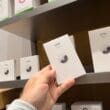 Consumidor pegando caixinha de AirTag em Apple Store