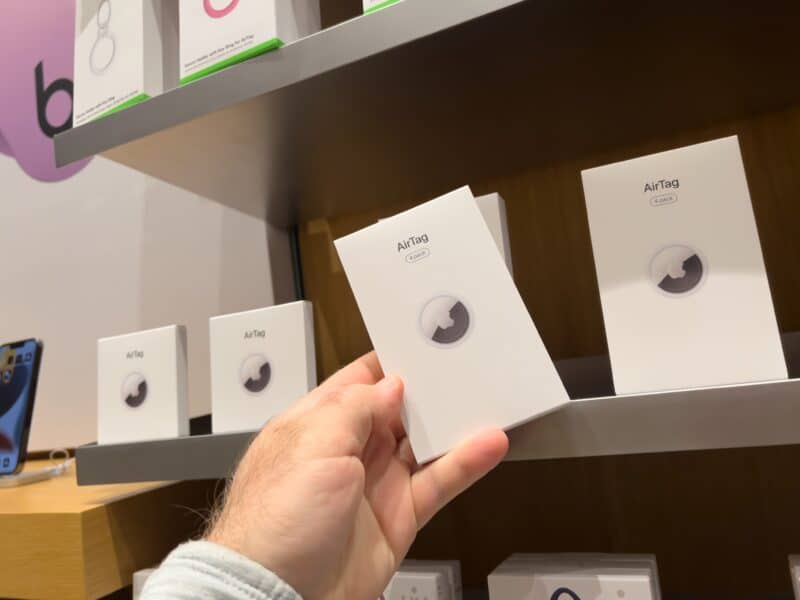 Consumidor pegando caixinha de AirTag em Apple Store