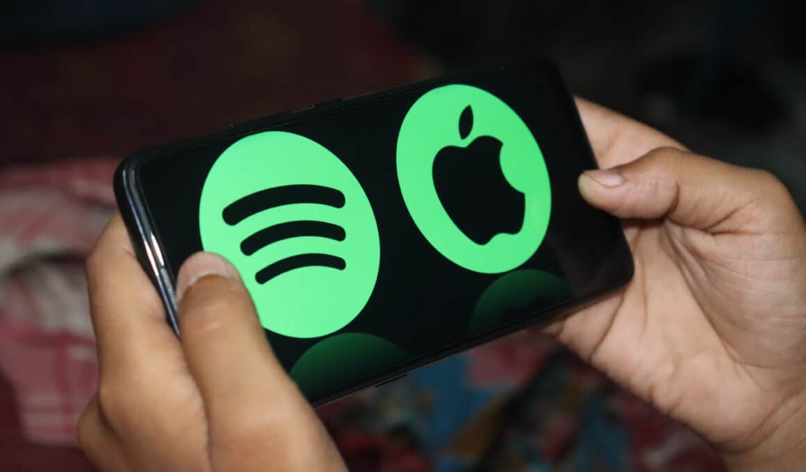 Logos da Apple e do Spotify em um smartphone