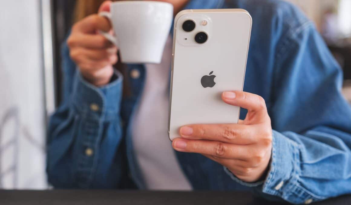 Mulher tomando café e usando o iPhone