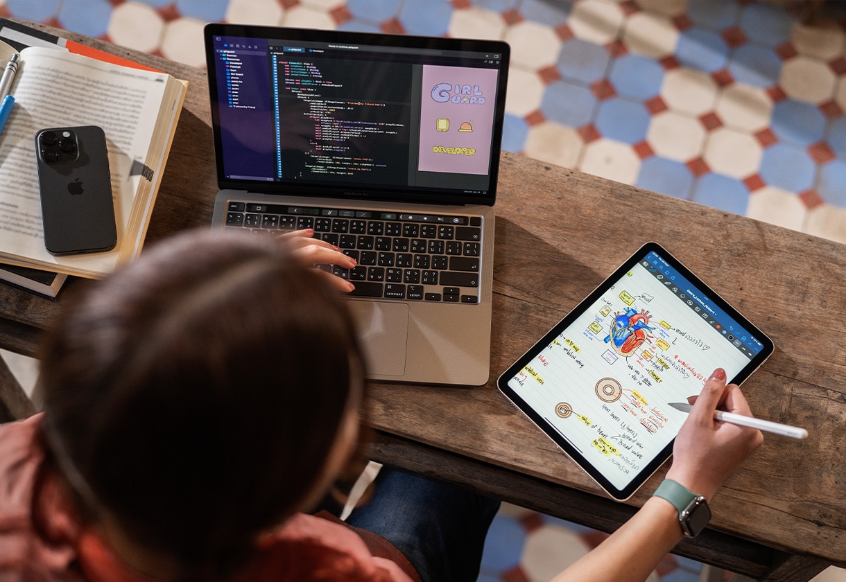 Woman using an iPhone, a MacBook Pro and an iPad