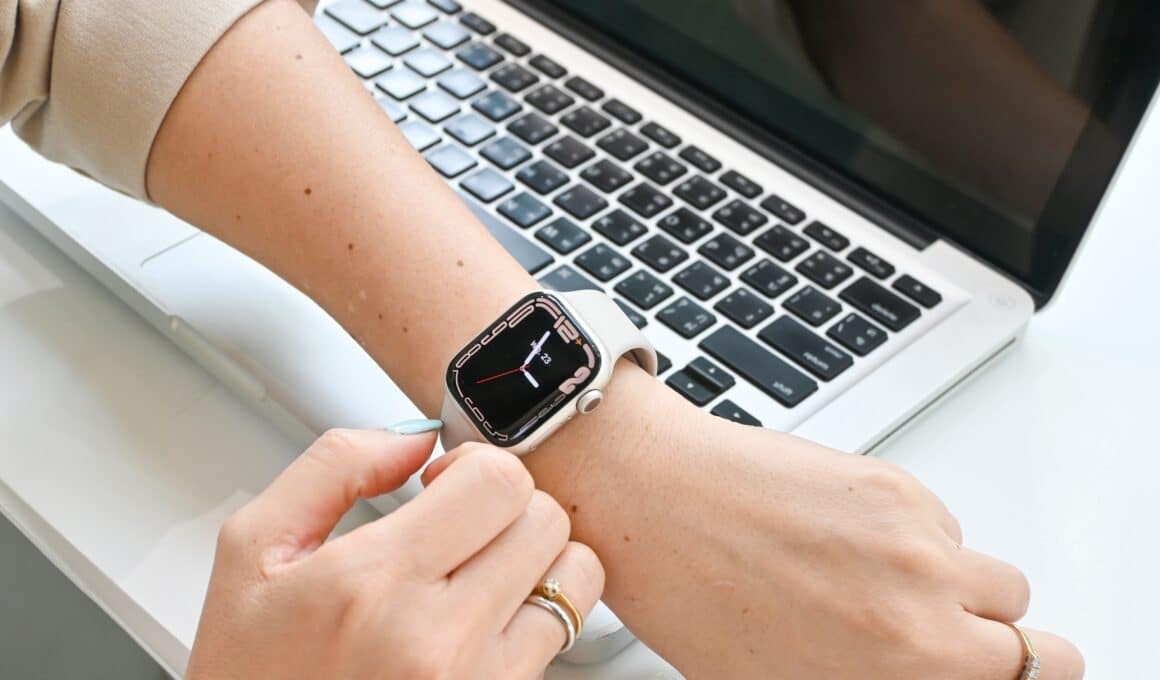 Mulher usando um Apple Watch com um Mac ao fundo