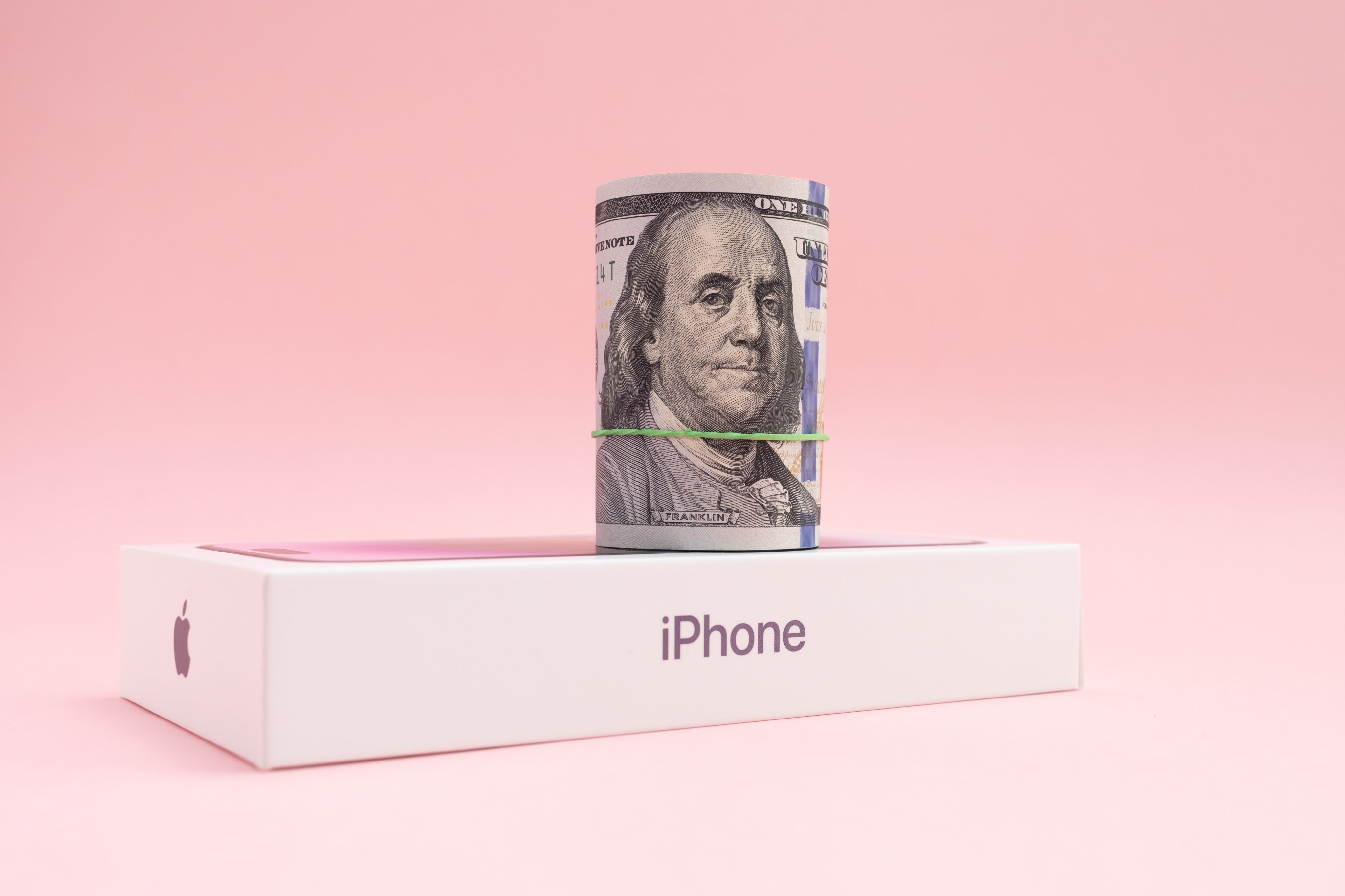 iPhone com um maço de dinheiro em cima