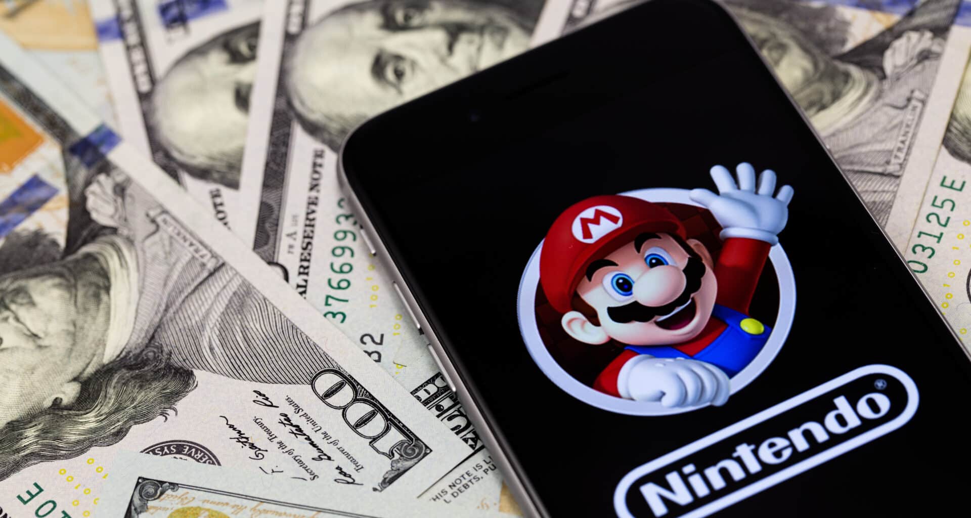 Logo da Nintendo e Mario em iPhone sobre notas de dólar