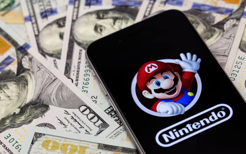 Logo da Nintendo e Mario em iPhone sobre notas de dólar