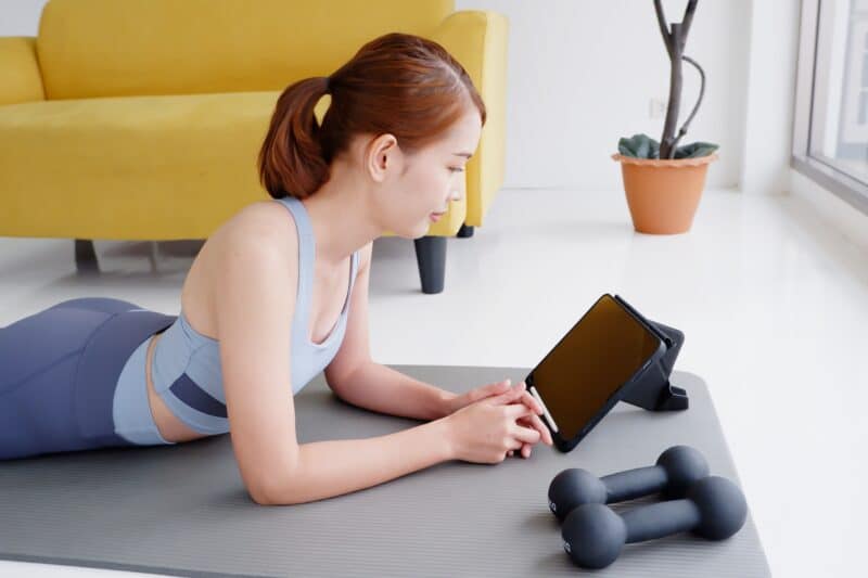 Mulher fazendo exercícios com um iPad