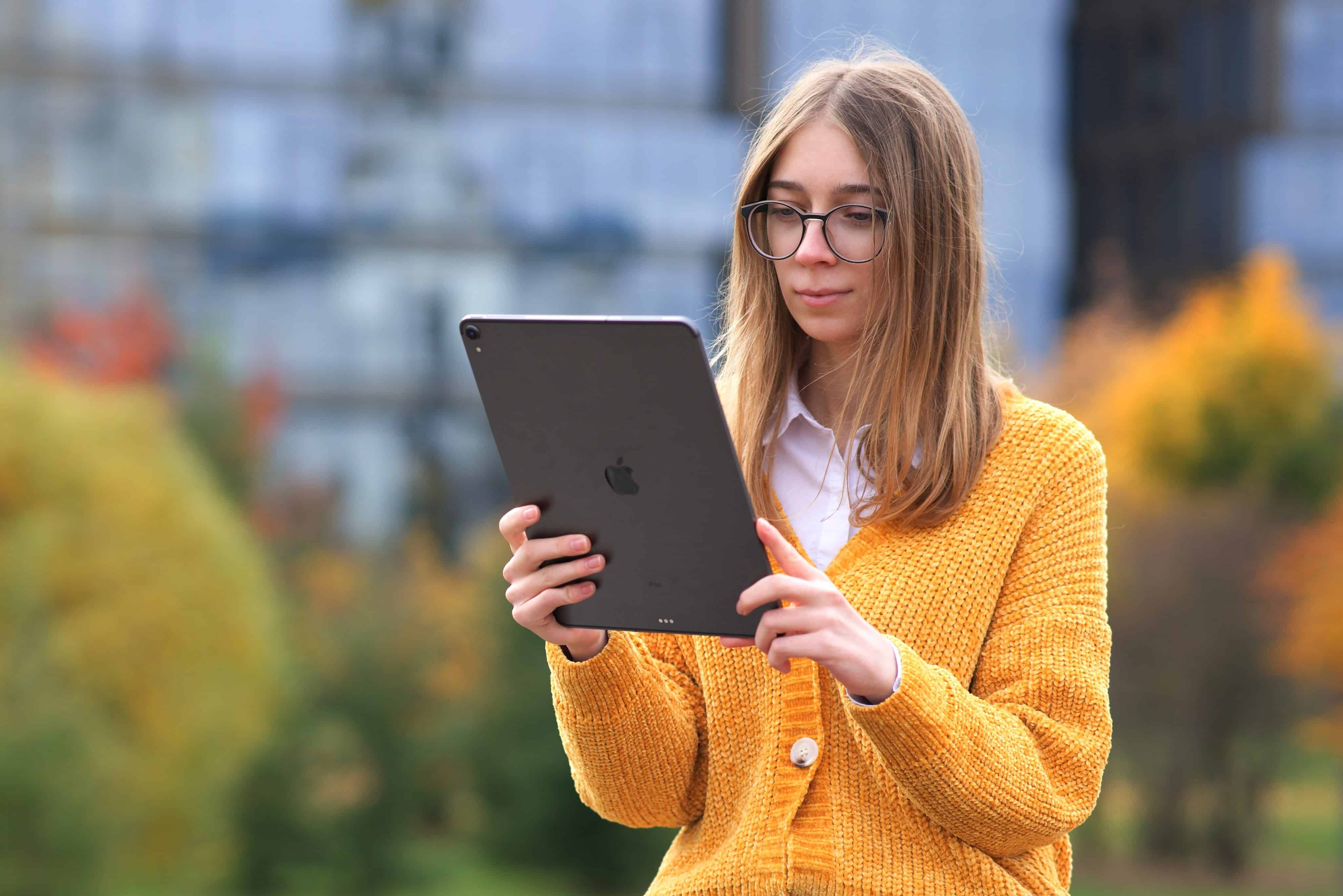 Menina usando um iPad Pro num parque