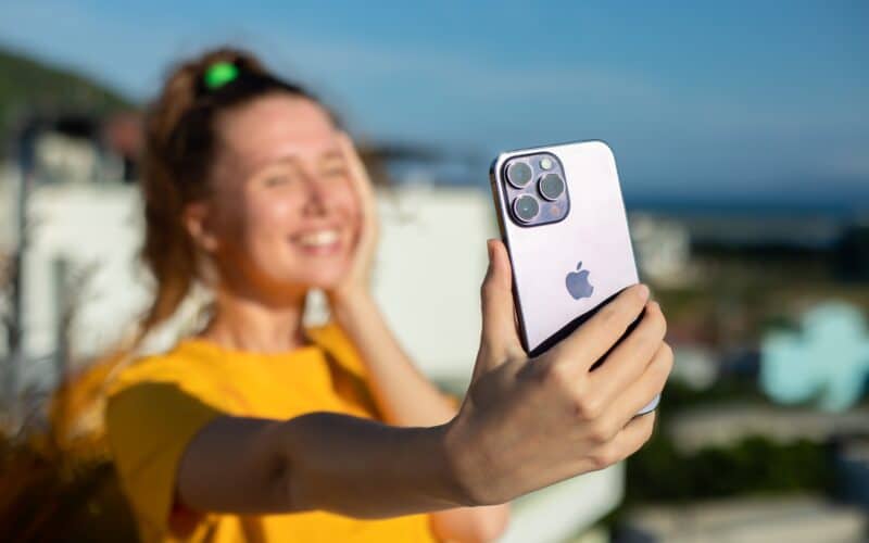 Mulher tirando uma selfie com um iPhone 14 Pro Max