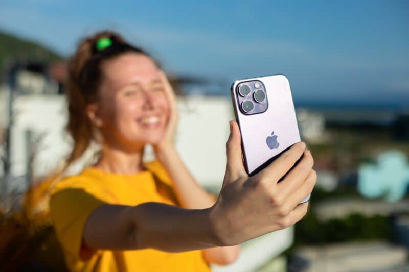 Mulher tirando uma selfie com um iPhone 14 Pro Max