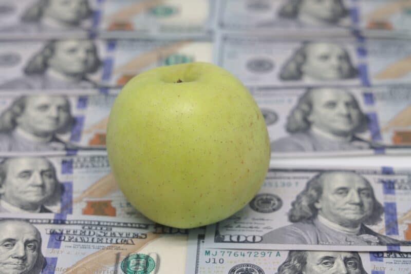 Uma maçã com dinheiro embaixo