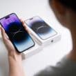 iPhone 14 Pro Max na mão de uma pessoa com a caixa ao fundo