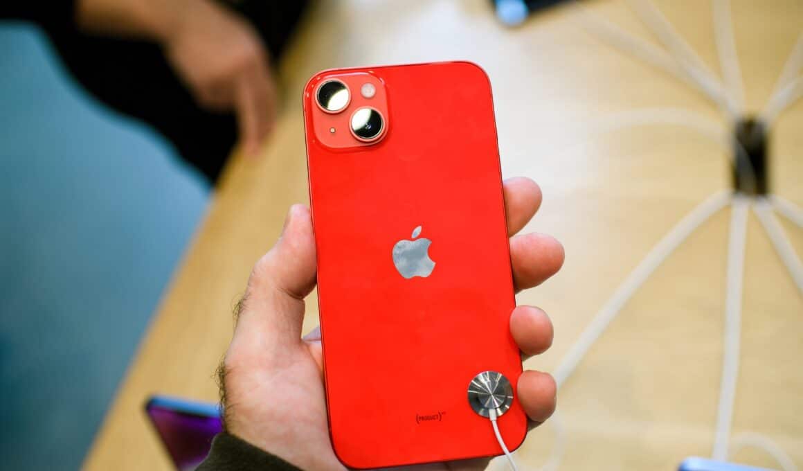 Mão segurando um iPhone 14 Plus vermelho